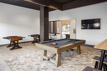 A games room with a pool table and a foosball table